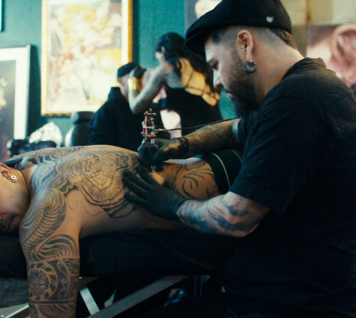Tatoueur en pleine séance au salon Freak Chic